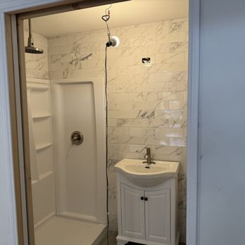 Finished bathroom shower installation with white subway tile walls.