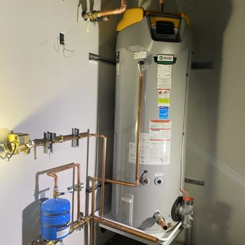 Professional water heater installation with new copper piping.