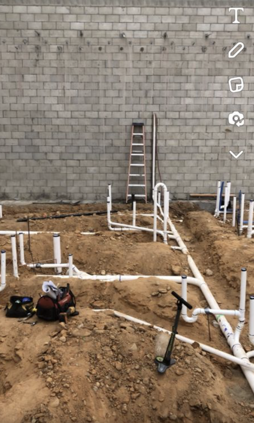 Underground plumbing rough-in with PVC drain lines.